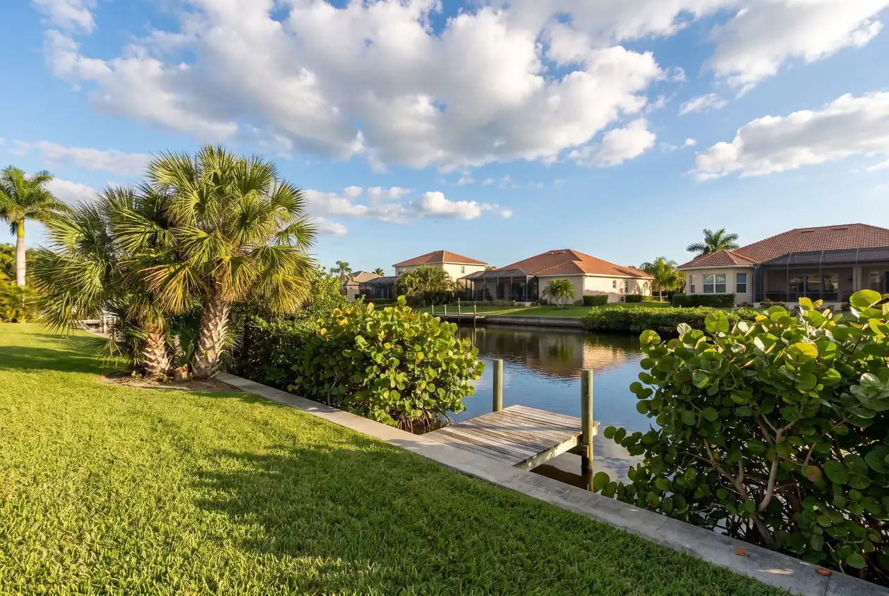 Lawn and palms along a calm residential canal