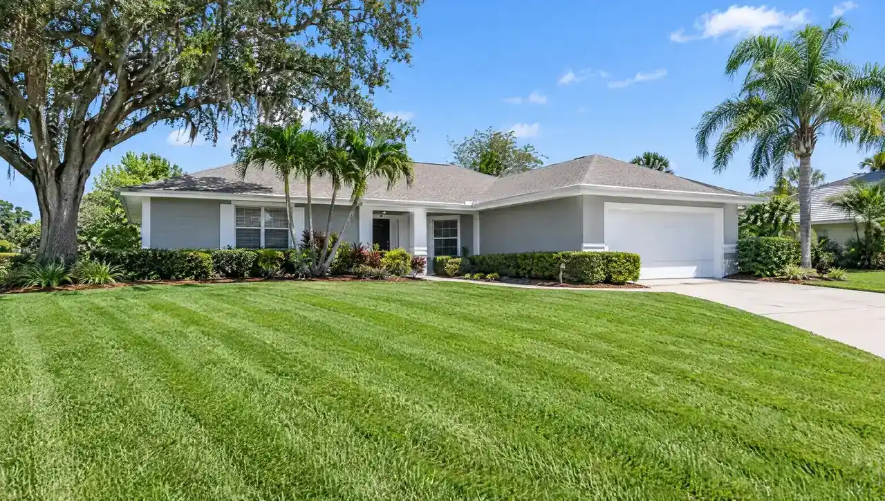 Single-story home with a live oak and a striped lawn
